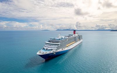 Carnival Luminosa sailing off Airlie Beach, Queensland, with islands on the horizon